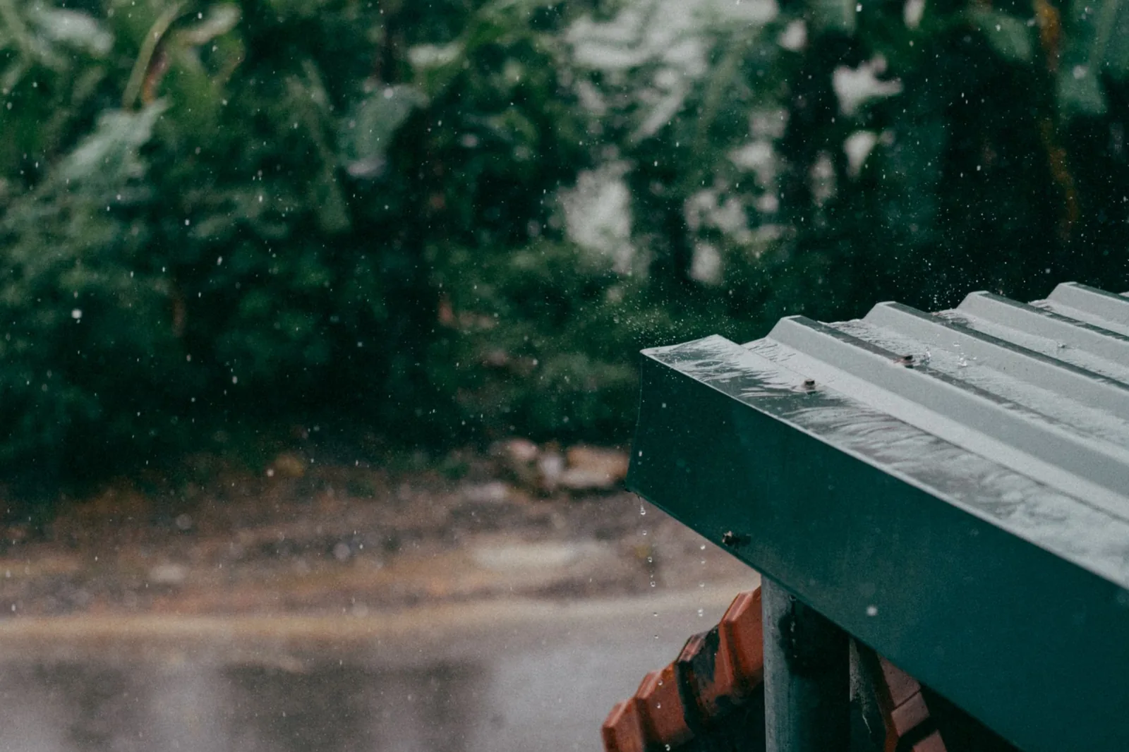 A close-up of a 6-inch half-round gutter and matching downspout installed on a Craftsman home